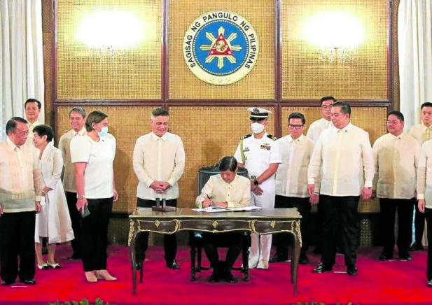 President Ferdinand Marcos Jr. signs the SIM Card Registration Act in a ceremony witnessed by Vice President Sara Duterte and leaders of the Senate and the House of Representatives at Malacañang on Monday, Oct. 10, 2022.