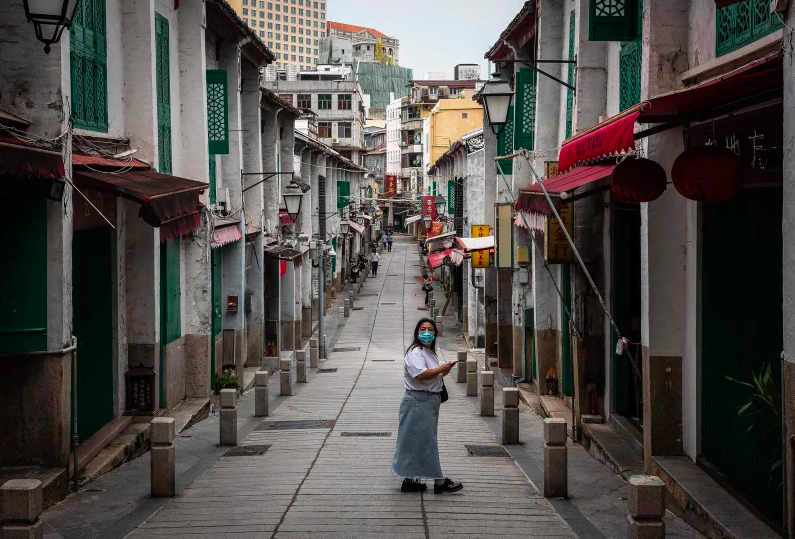 A woman looks as she walks in a historical street in Macau.
