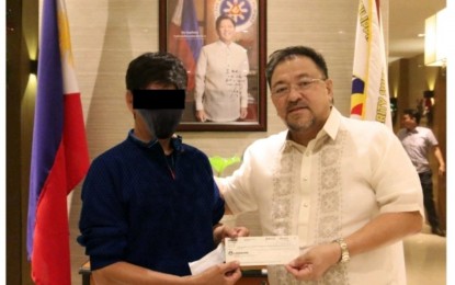 WINNER. PCSO GM Melquiades Robles (right) on Tuesday (Nov. 8, 2022) hands over the check worth over PHP 188.4 million to the winner of the Oct. 23, 2022, Super Lotto 6/49 draw. The bettor said he has been playing Lotto and trying his luck for over 20 years. (Image source: PCSO)