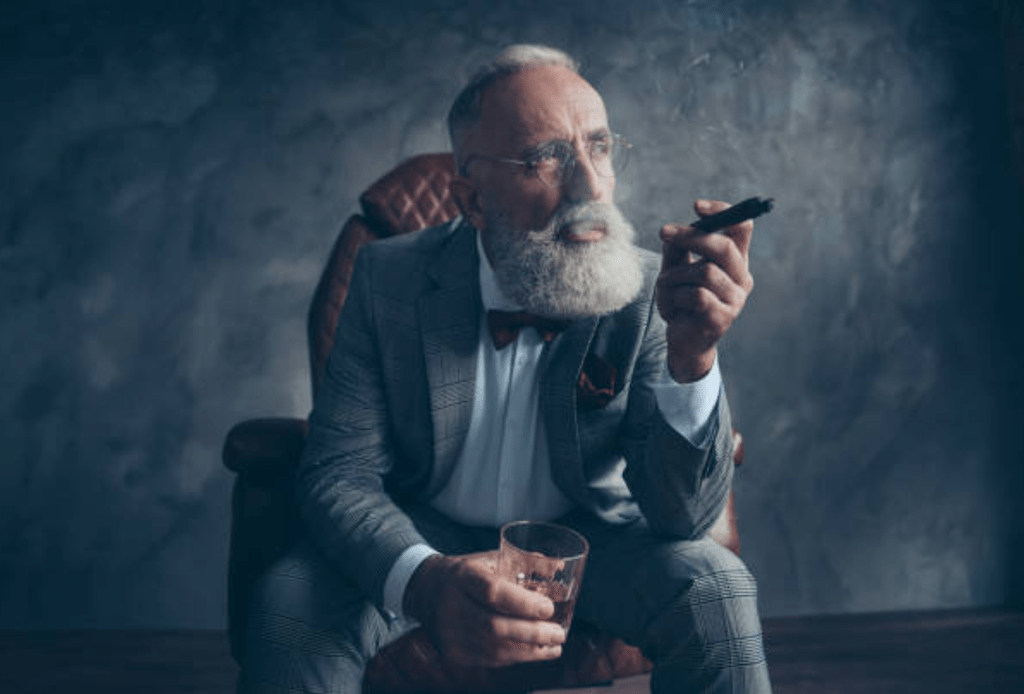 Old rich man holding cigarette and a glass of whiskey